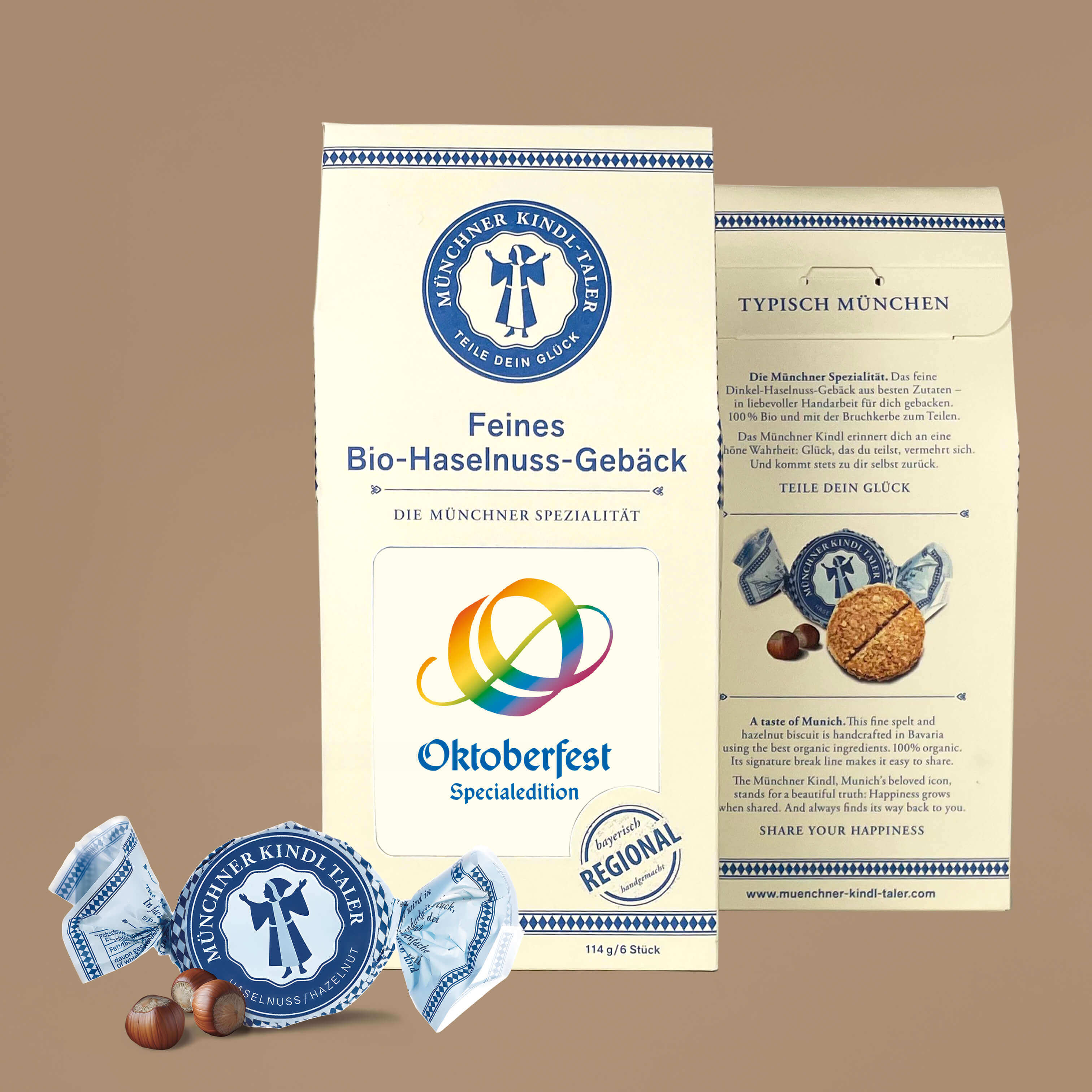 Cremefarbener Karton mit Sichtfeld mit dem Oktoberfest Logo in Regenbogen Farben. Secs einzeln verpackte Münchner Kindl-Taler in blau. 114g